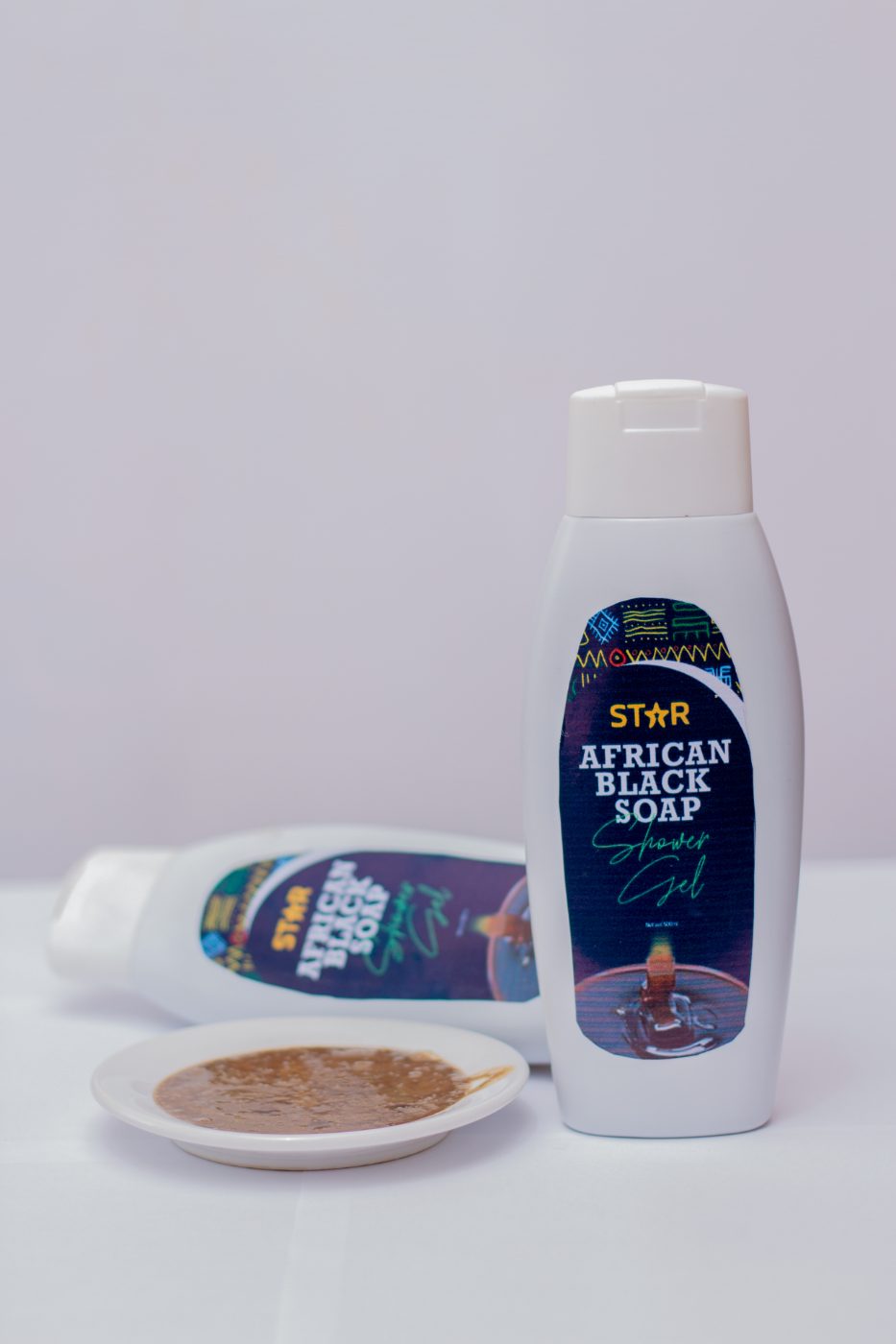 STAR African Black Soap shower gel bottles beside a dish of raw black soap